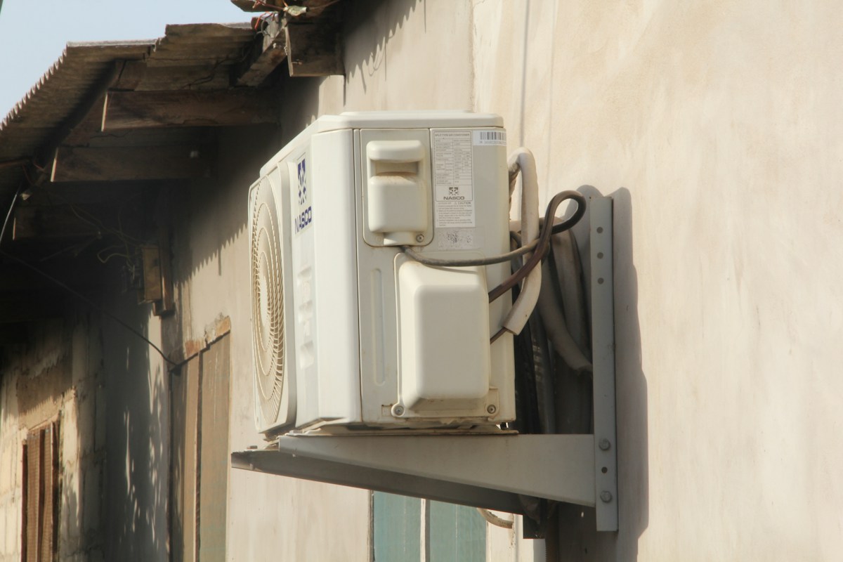 Unidade condensadora de ar-condicionado fixada em suporte na parede externa